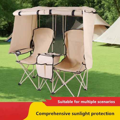 Double camping chair with canopy on grass with trees in the background